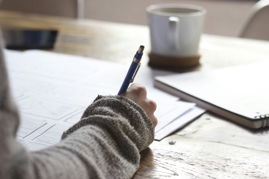 Researcher working at a desk with notes and technology